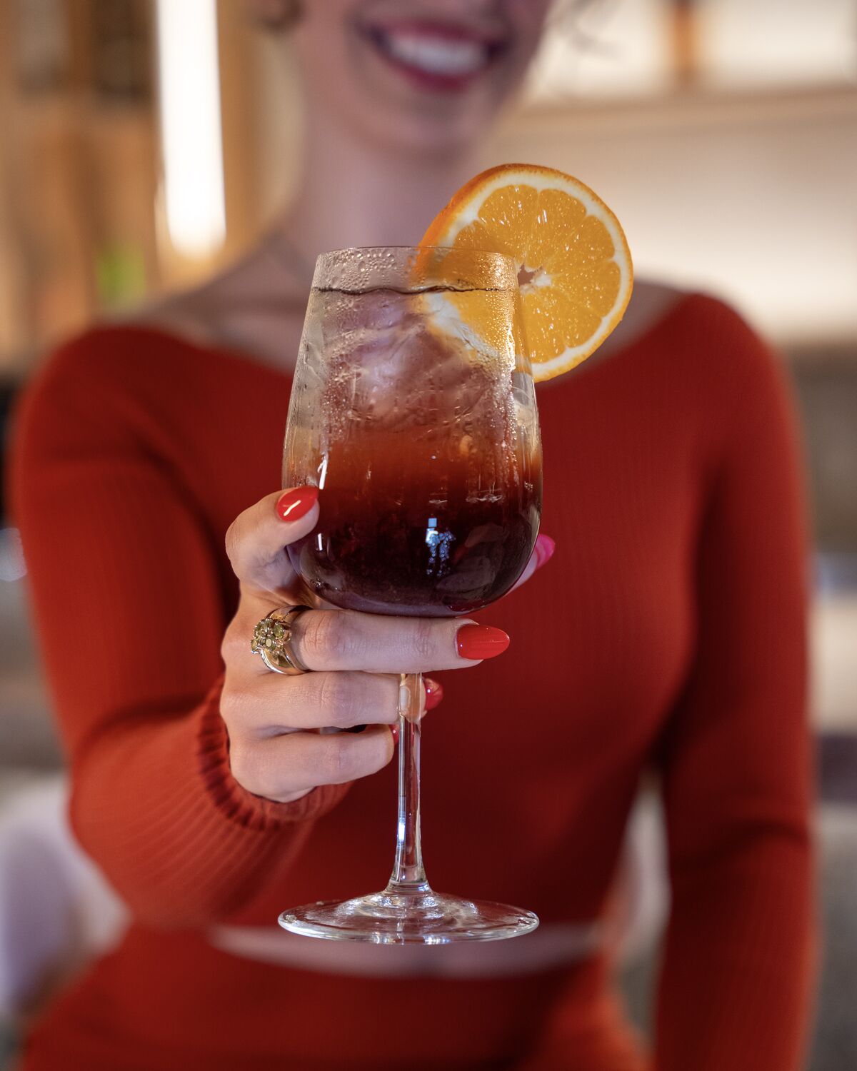 Guest holding a sangria garnished with fresh orange in Manhattan Beach