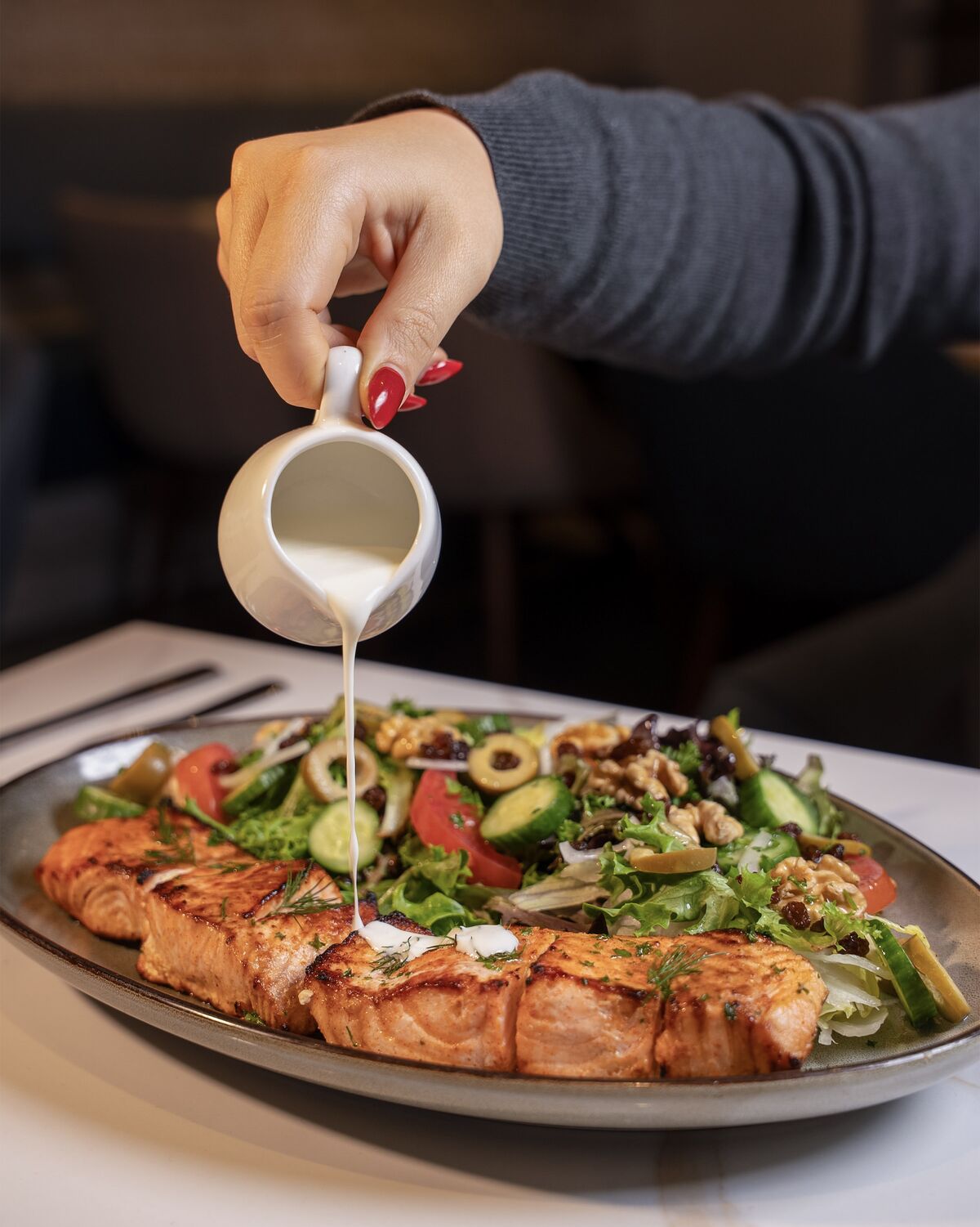 Creamy dressing poured over grilled salmon and salad in Westwood Village